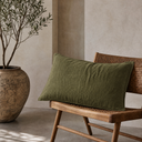 Relaxed moss green linen euro sham styled on wooden chair with olive branch decor