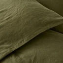 Close-up of moss green linen pillowcase showing natural French flax texture and visible stitching