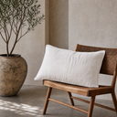 Soft white linen euro sham on rattan chair with olive branch